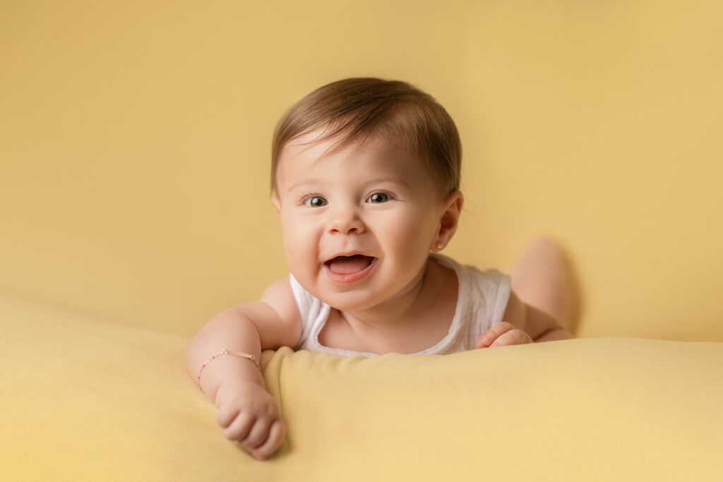Sesion de fotos bebe tierna sonriendosobre fondo amarillo. Sesion de bebes en mendoza